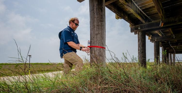 In addition to relying on data from more expensive 哨兵, engineering professor Dr. Bret Webb will deploy smaller storm surge and wave gauges in advance of a hurricane. They can be affixed to structures such as this pier on Dauphin Island. data-lightbox =“特色”